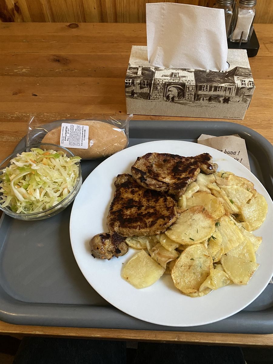 Ceafă la grătar cu cartofi și salată de varză, pe tavă.